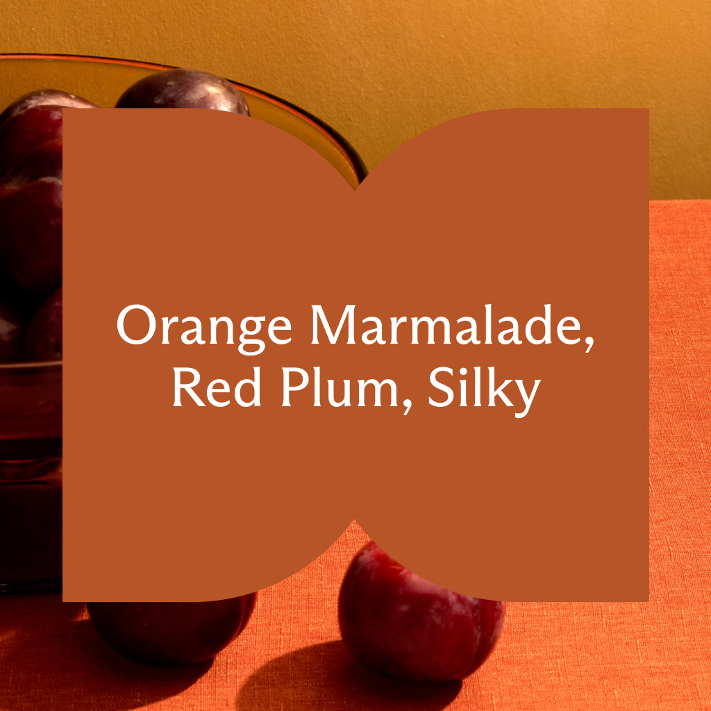 Close-up of red plums with a text overlay on an orange background. Text: Orange Marmalade, Red Plum, Silky