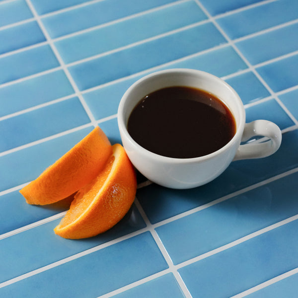 Cup of Bolivia coffee next to some oranges