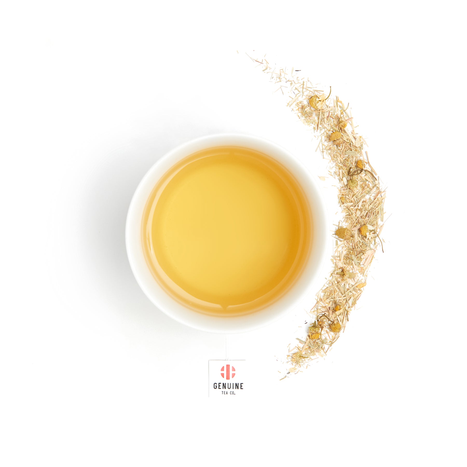 Overhead view of a brewed cup of Organic Chamomile Lemongrass tea, next to some tea leaves