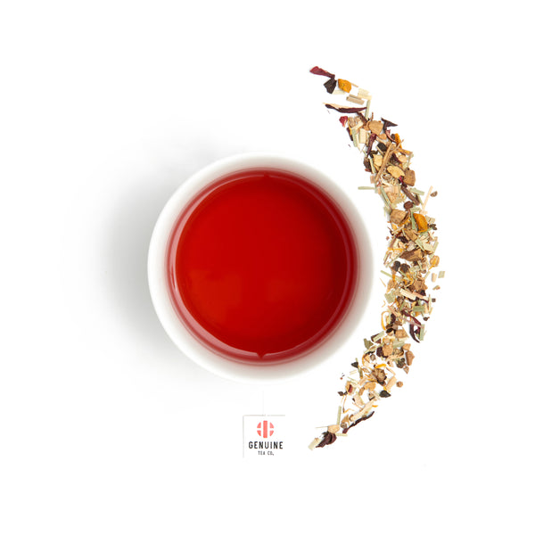 Overhead view of a brewed cup of Organic Turmeric tea, next to some tea leaves