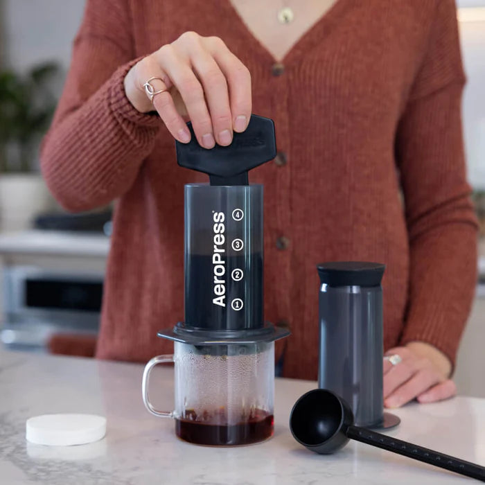 Person using Aeropress coffee maker